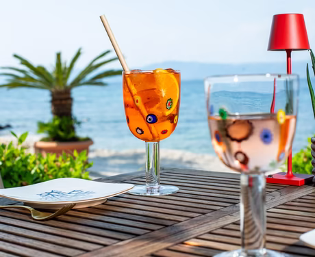 Ein Aperol und ein Prosecco auf gedecktem Tisch direkt neben dem Meer an der Strandbar