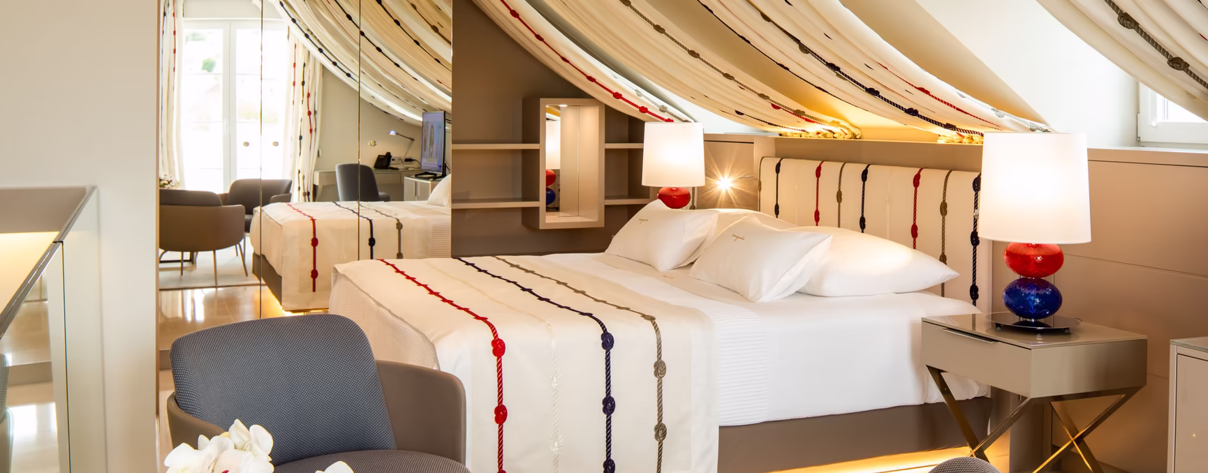 großer Wohnraum mit Doppelbett, kleinem Schreibtisch und Nachttisch