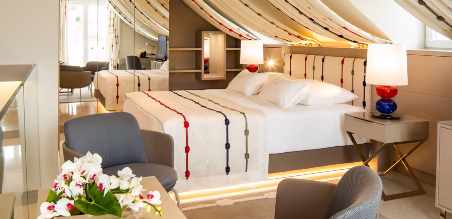 großer Wohnraum mit Doppelbett, kleinem Schreibtisch und Nachttisch