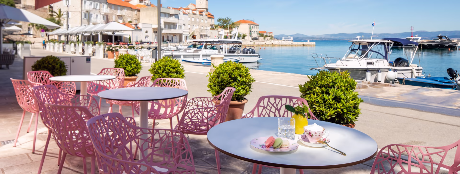 Sitzmöglichkeiten am Meer mit Rosa Stühlen bei Sonnenschein