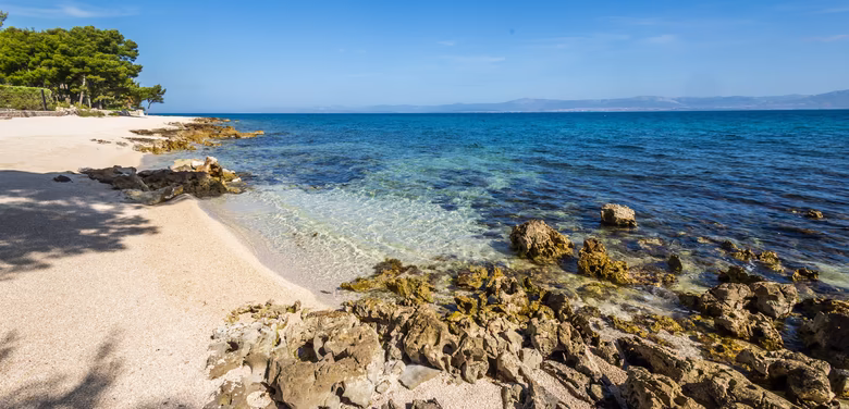 Kristallklares blaues Meer mit Stein Strand 