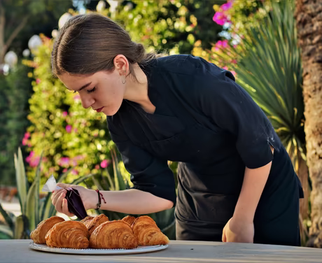 Feines Konditorhandwerk © Hotel Lemongarden Frau spritzt Frucht Konfitüre in Butter Croissants