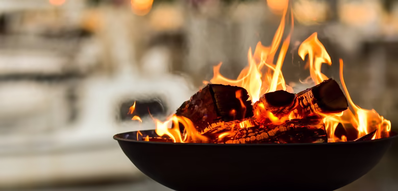 Feuerschale mit viel Holz und bei Abendstimmung