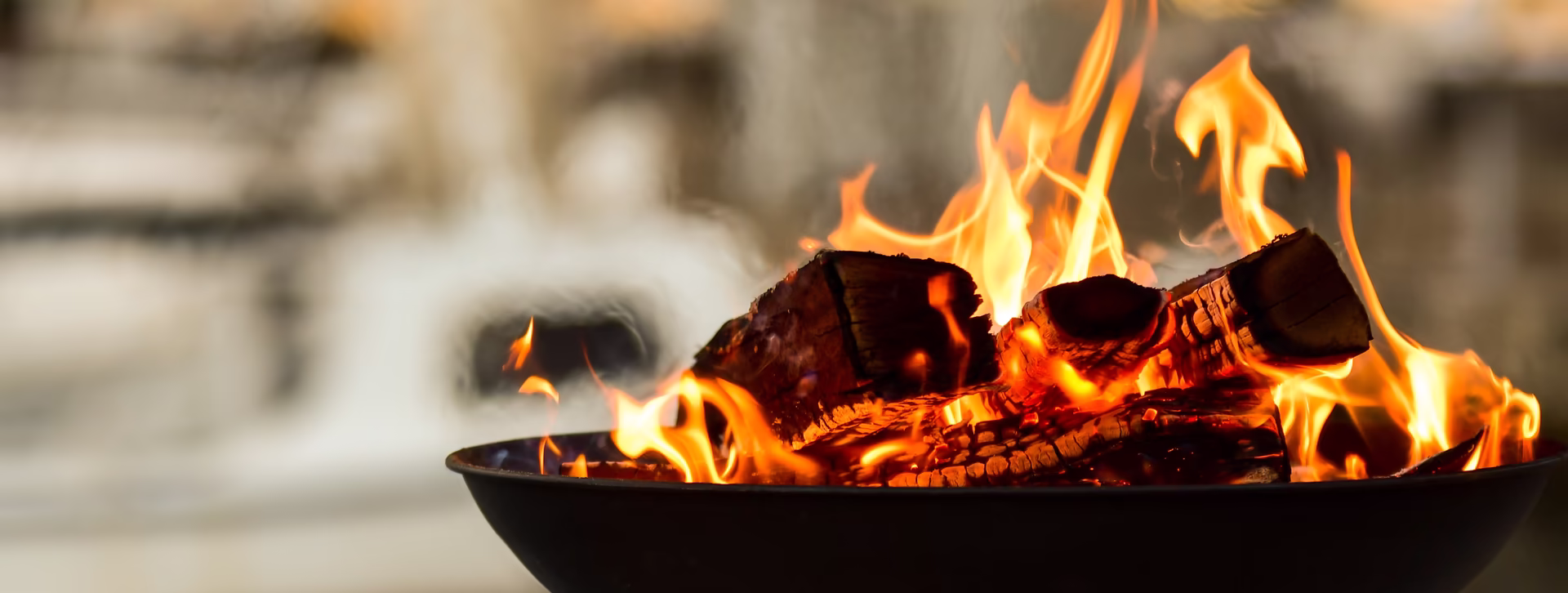 Feuerschale mit viel Holz und bei Abendstimmung