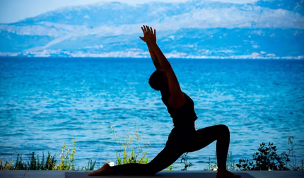 Yoga am Strand mit dem Meer im Hintergrund