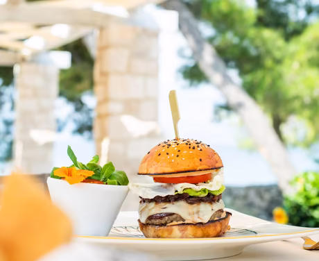 Erstklassiger Burger © Hotel Lemongarden großer Burger serviert mit einem Salat an der Strandbar mit Blick aufs Meer