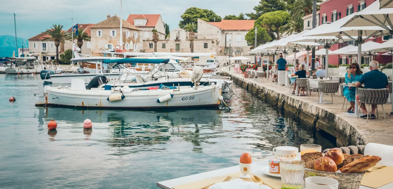 Gedeckter Frühstückstisch direkt am Meer mit Booten