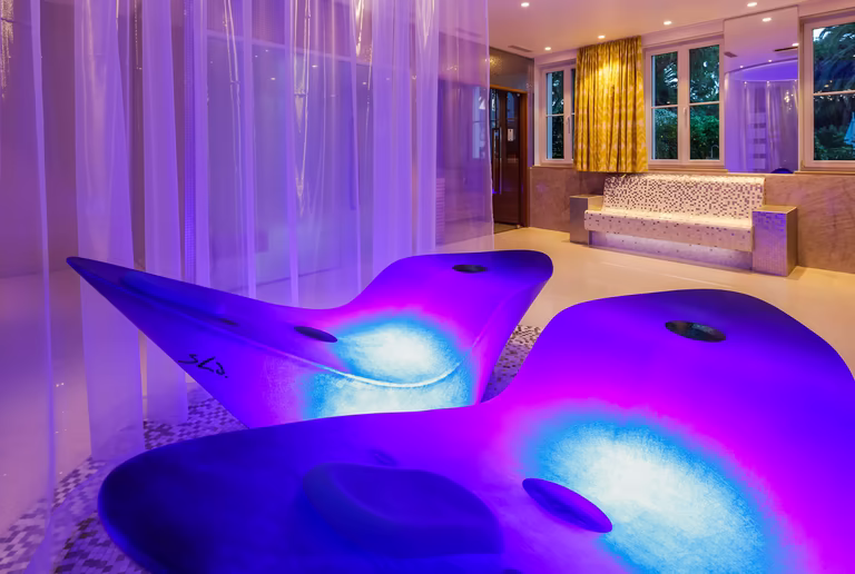 zwei Alphasheren Liegen im privat SPA Bereich mit blau / lila Beleuchtung