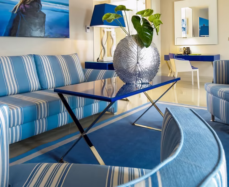 Lounge mit Tisch, Couch und Stühlen im blauen Farbschema