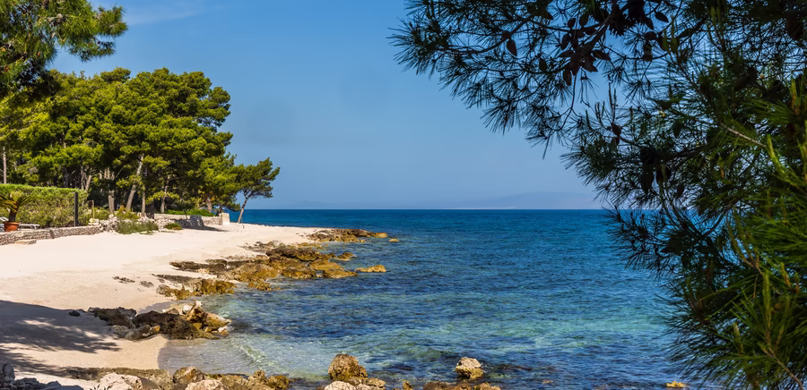 Kroatischer Strand mit Steinen und Kristallblauem Wasser