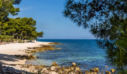 Kroatischer Strand mit Steinen und Kristallblauem Wasser
