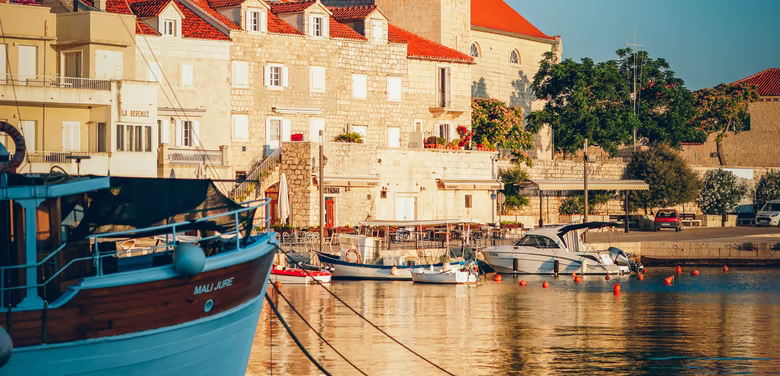 Kroatischer Kirchturm direkt am Hafen bei Sonnenaufgang
