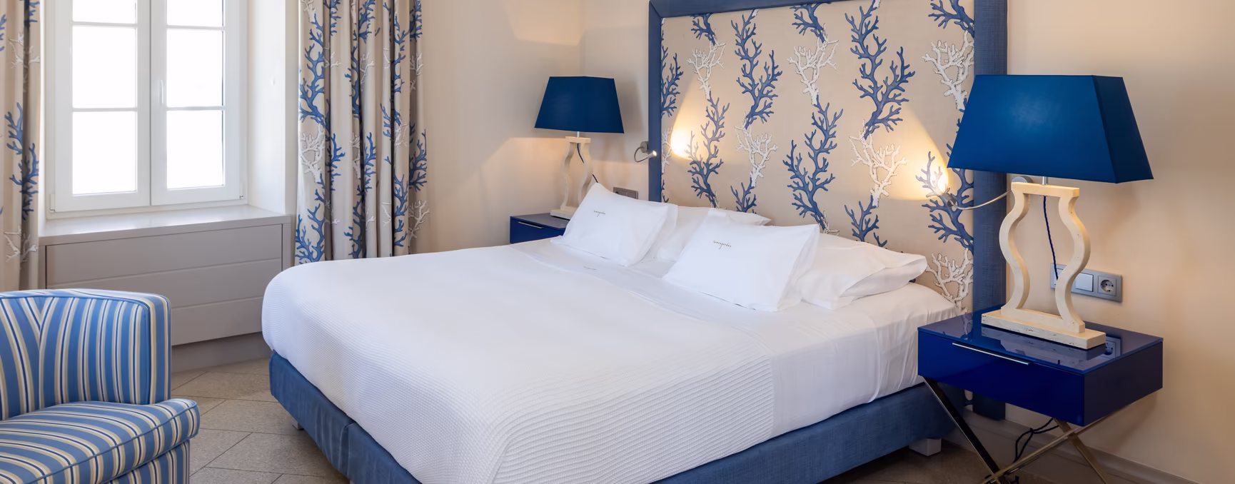 großes Doppelbett mit hoher Kopfstütze im blauen Farbton