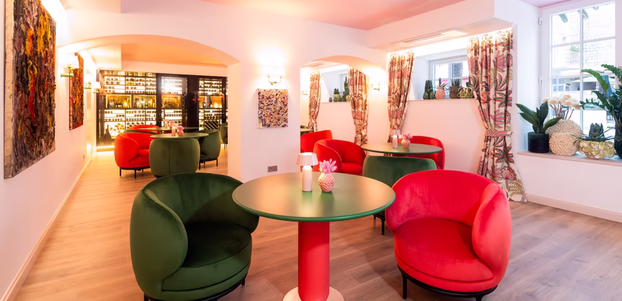 viele Sitzmöglichkeiten aus rot / grünen Stühlen in der Weinlounge 