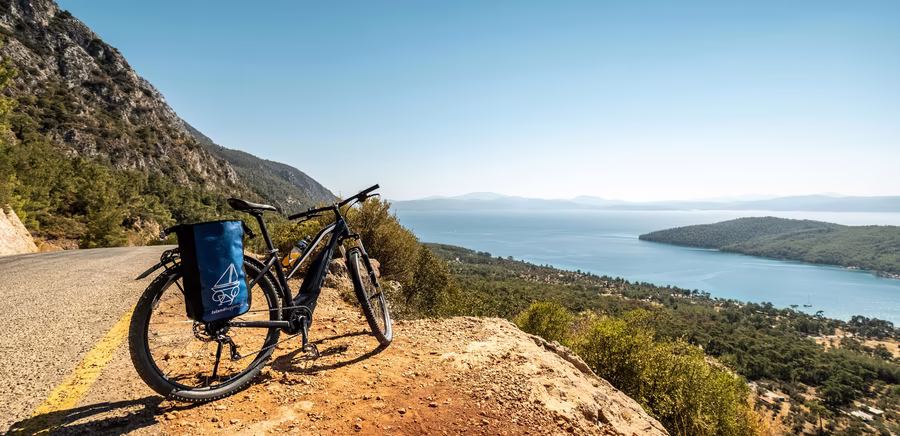 Fahrrad auf braunem Schotter mit Aussicht auf das Meer