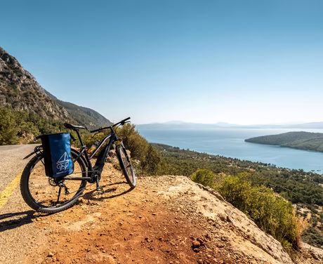 Fahrrad auf braunem Schotter mit Aussicht auf das Meer