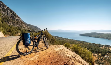 Fahrrad auf braunem Schotter mit Aussicht auf das Meer