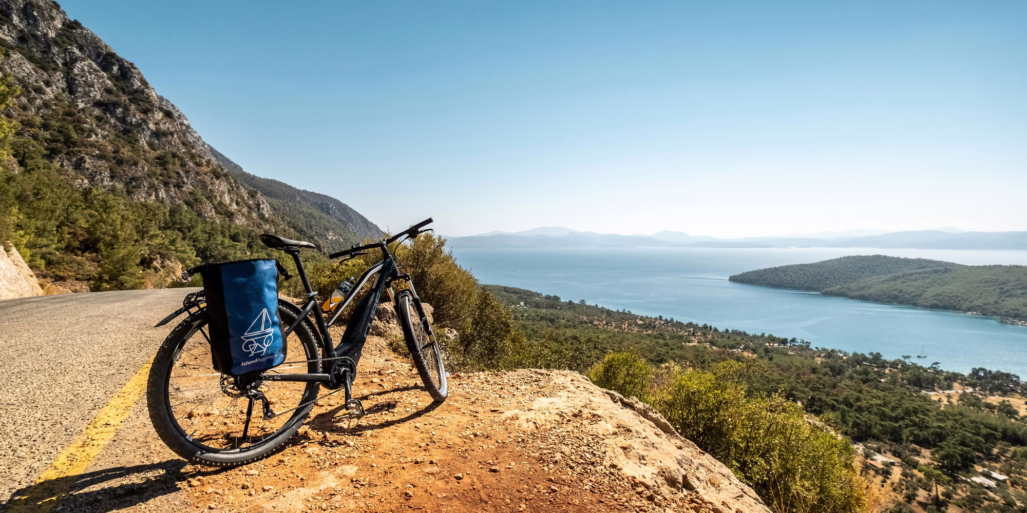 Fahrrad auf braunem Schotter mit Aussicht auf das Meer