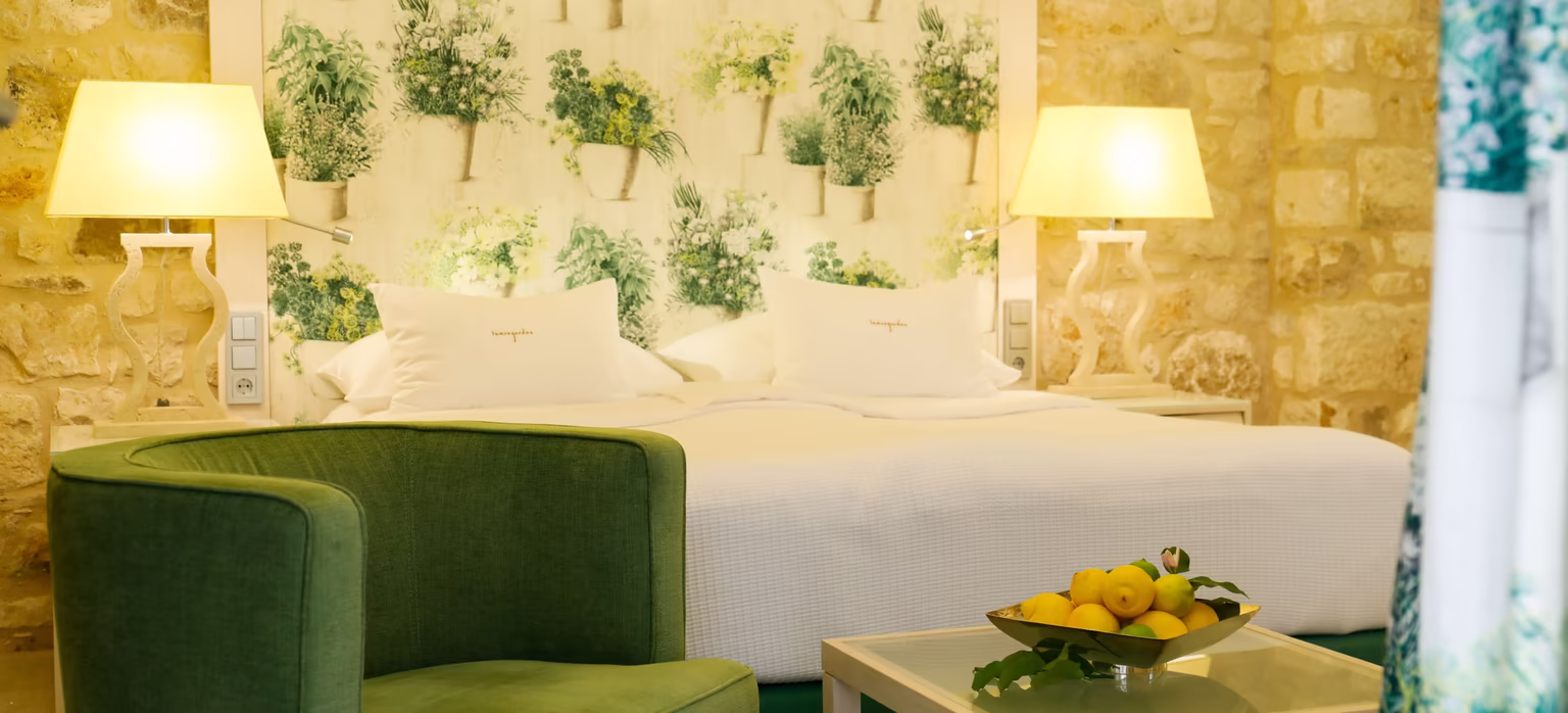 Exklusives Doppelbett, Superior Doppelzimmer © Hotel Lemongarden großes Doppelbett mit Sitzgarnitur und kleinem Glastisch in grüner Farbe