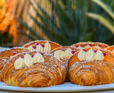 Süße Vanille Croissants mit Staubzucker und kleinen roten Beeren