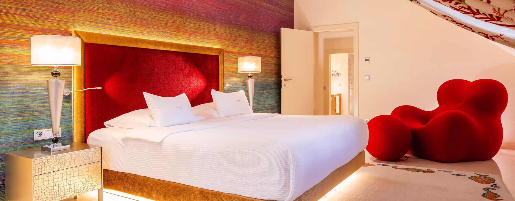 Zimmer im Rotton mit großem Doppelbett und Dachschräge
