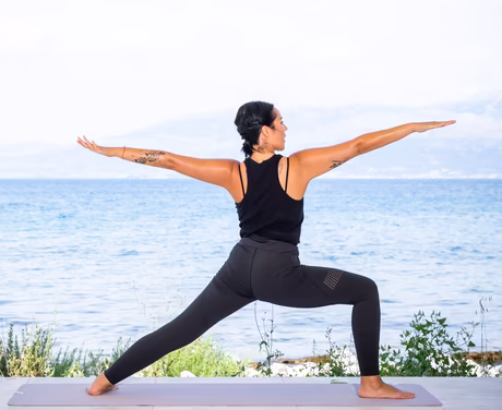 Yogalehrerin macht eine Figur am Strand