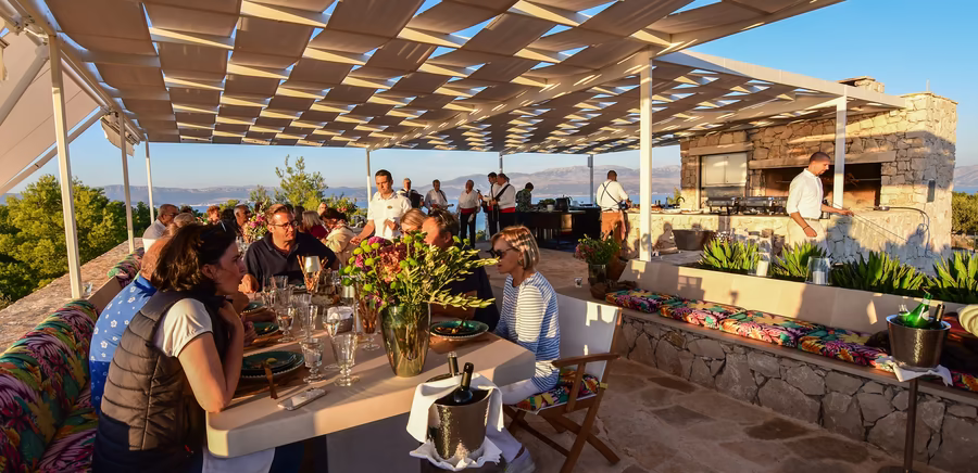 Gemeinsames Abendessen bei Abendstimmung auf einer Dachterrasse